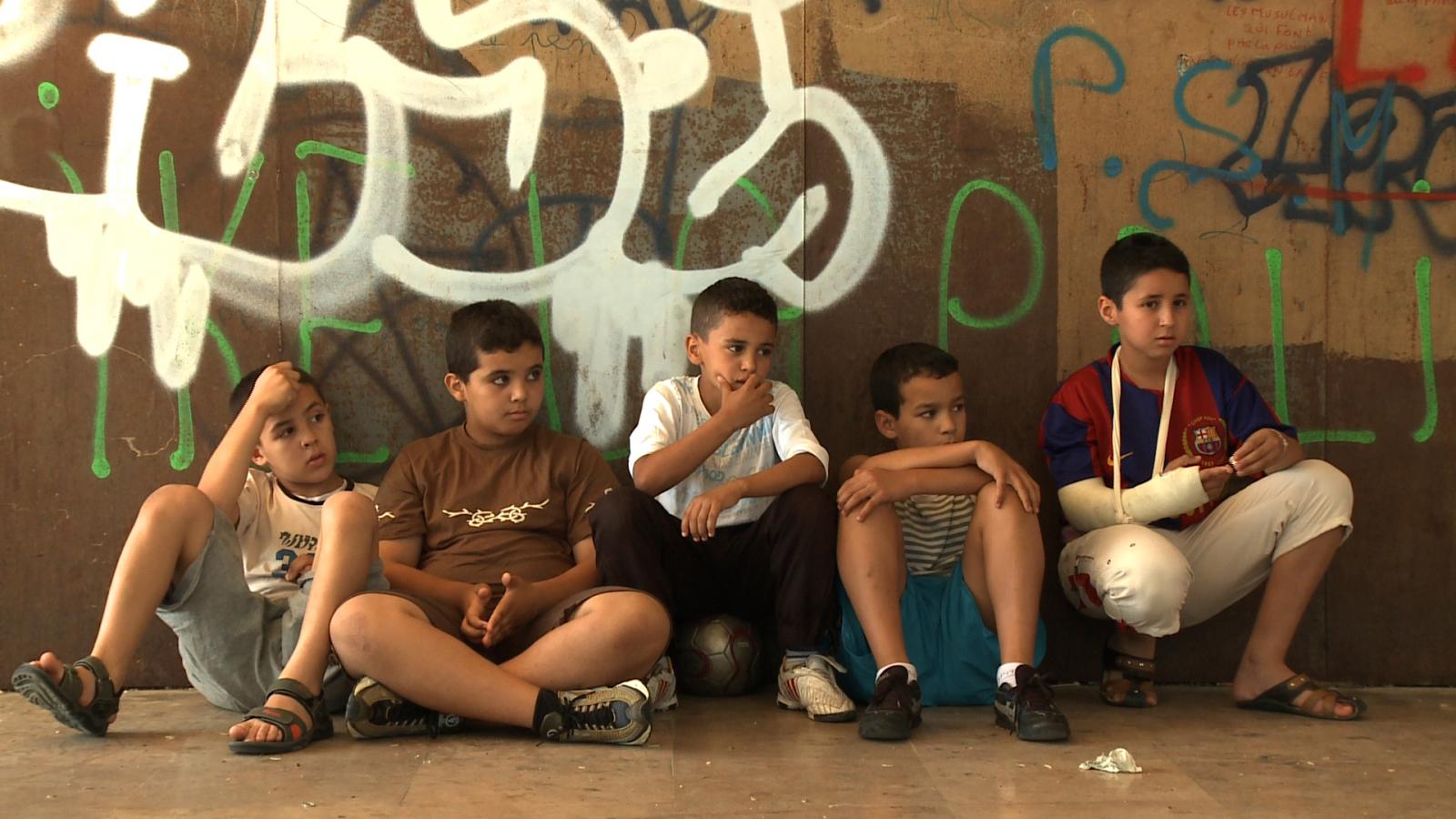 Enfants assis contre un mur