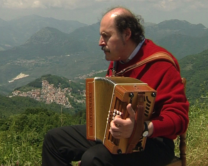 Marc Perrone jouant de l'accordéon dans les montagnes