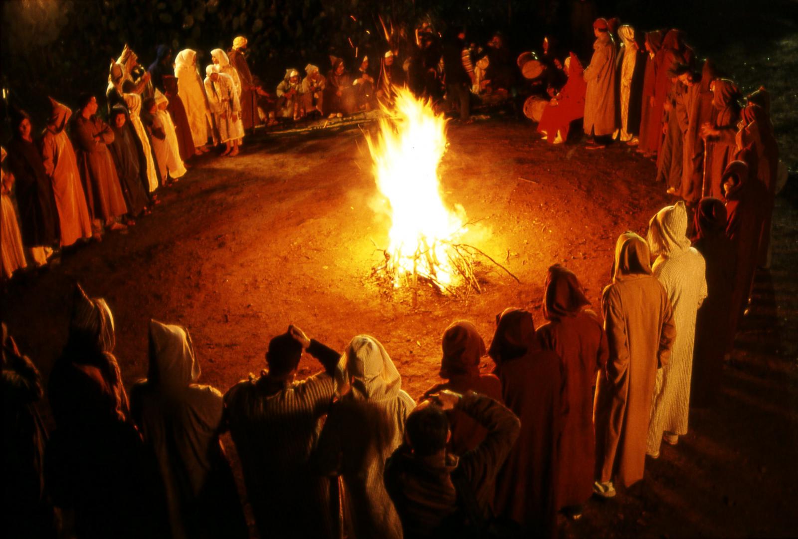 Groupe de personnes en cercle autour d'un feu